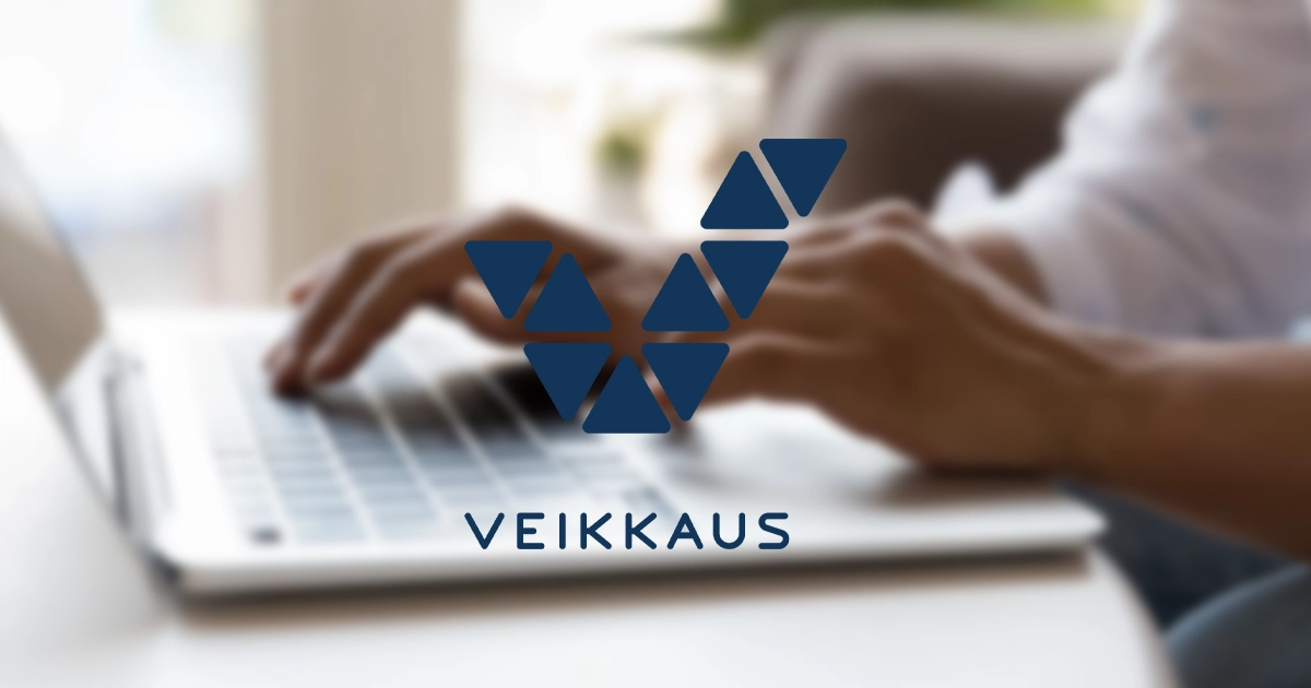 Logo veikkaus sur un fond flouté montrant une personne tapant sur le clavier d'un ordinateur portable