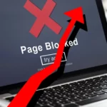 A laptop showing a blocked website page with a red arrow pointing upwards.