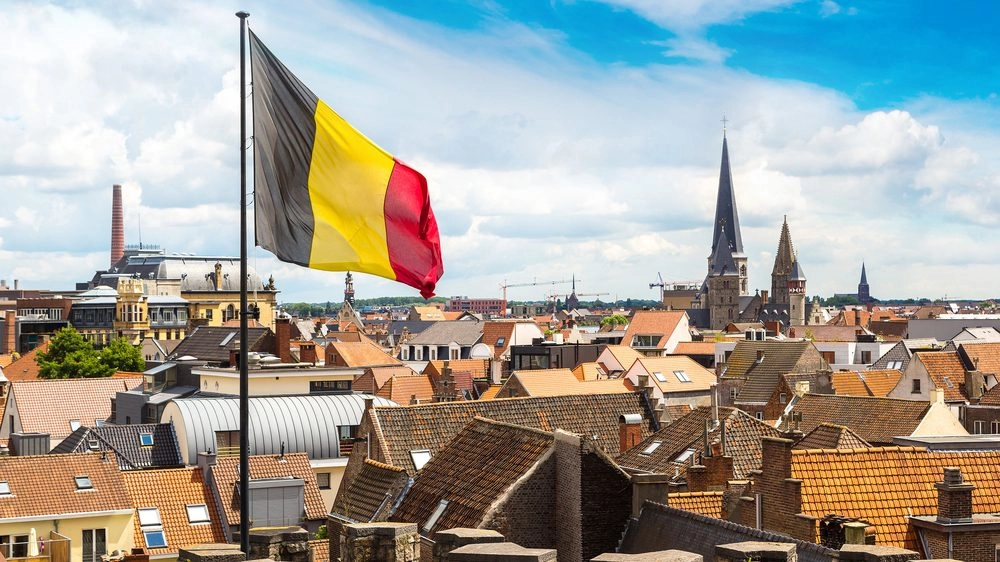Belgische vlag met op de achtergrond zicht op belgië