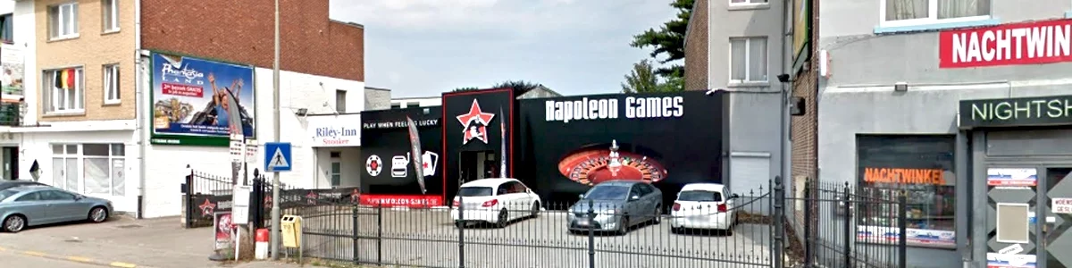 The napoleon games casino located in genk, with 3 cars in the parking lot in front.