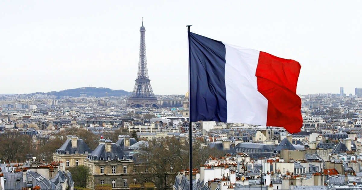 Vue des toits de paris avec la tour eiffel et le drapeau français.