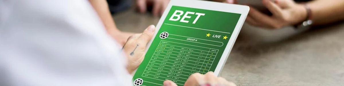 A man making a sports bet on a tablet