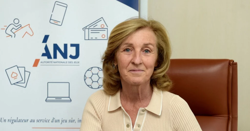 Isabelle Falque Pierrotin in een fauteuil met een ANJ-bordje op de muur erachter