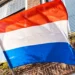 Dutch flag in front of a house facade.